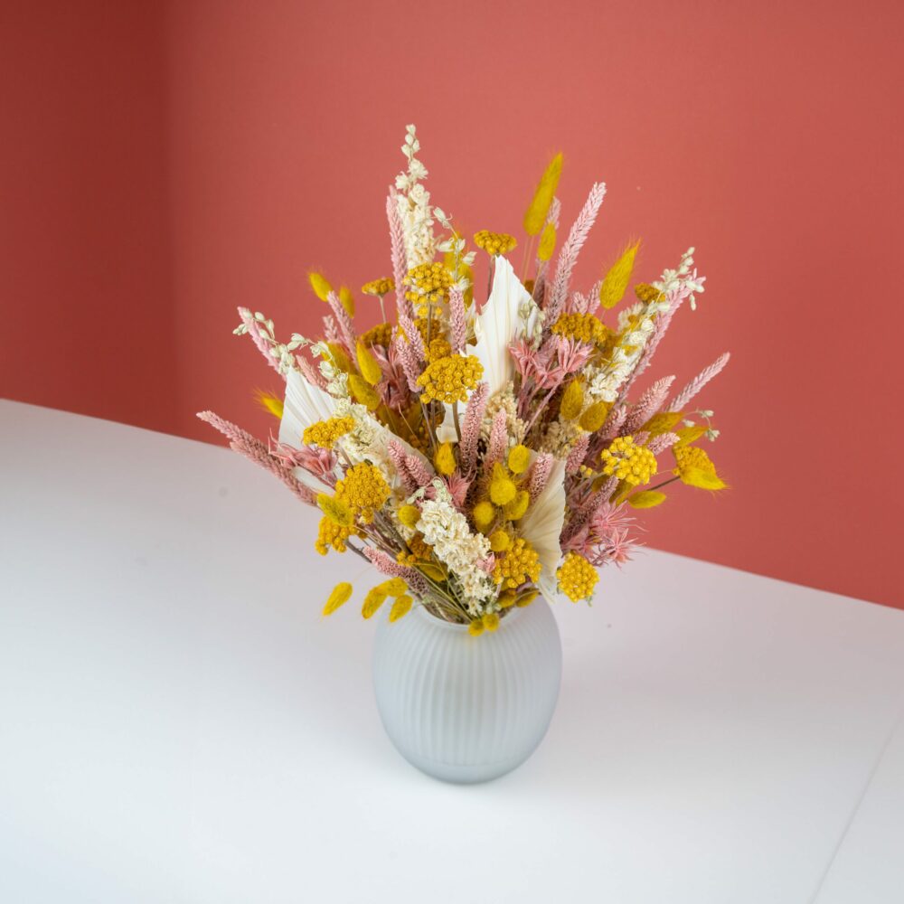 bouquet de fleurs séchées vu dessus sur fond rose et blanc